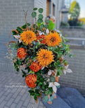 A large tombstone with red and orange chrysanthemum