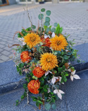 Une grande pierre tombale avec un chrysanthème rouge et orange