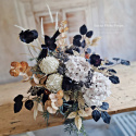 Tombstone decoration in a basket with black poppies and hydrangea and artichokes