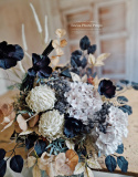 Décoration de pierre tombale dans un panier avec des coquelicots noirs et des hortensia et des artichauts